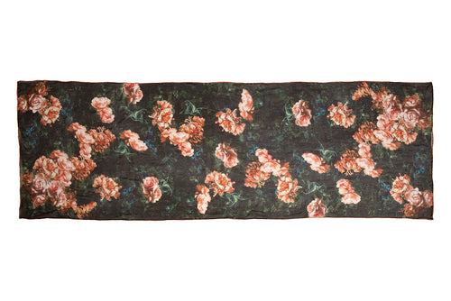 Scarf displayed flat. The design is inspired by a painting, with pink flowers on a green background.